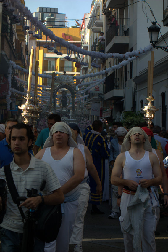 Un grupo de costaleros junto a la imagen de la patrona por las calles de centro de la ciudad. 